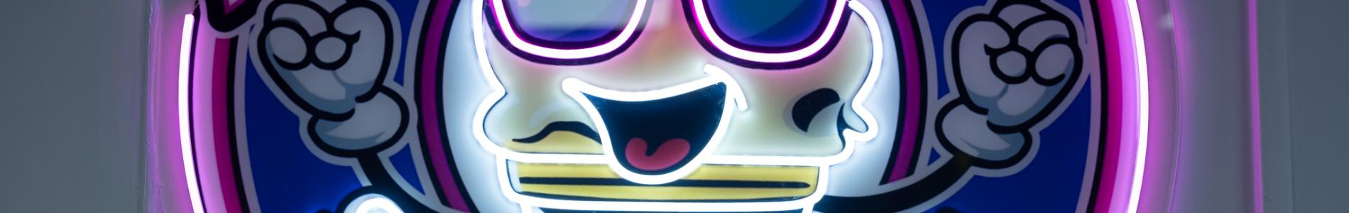 Neon sign featuring a smiling ice cream cone wearing sunglasses with the text “Smiling Scoops” in pink and white